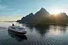 MS Nordnorge i solnedgang, med Vågakallen i Lofoten i bakgrunnen.