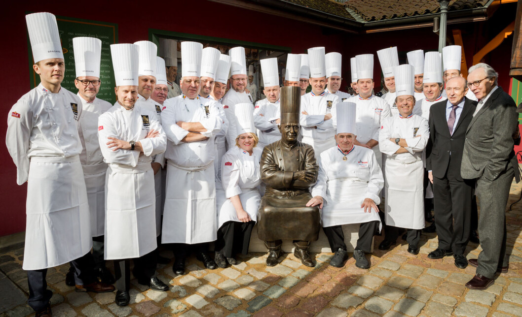 Paul Bocuse feiret 90-årsjubileet med mange av Bocuse d'Or-vinnerne, deriblant nordmennene Geir Skeie (helt til venstre), Bent Stiansen (midt i bildet), Ørjan Johannessen og Charles Tjessem (litt til høyre for midten). Paul Bocuse feiret 90-årsjubileet med mange av Bocuse d'Or-vinnerne, deriblant nordmennene Geir Skeie (helt til venstre), Bent Stiansen (midt i bildet), Ørjan Johannessen og Charles Tjessem (litt til høyre for midten).