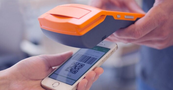 Kundens app skannes i butikken, og beløpet trekkes fra hans eller hennes konto i Kina for å overføres til butikkens konto gjennom Alipay. Kundens app skannes i butikken, og beløpet trekkes fra hans eller hennes konto i Kina for å overføres til butikkens konto gjennom Alipay.