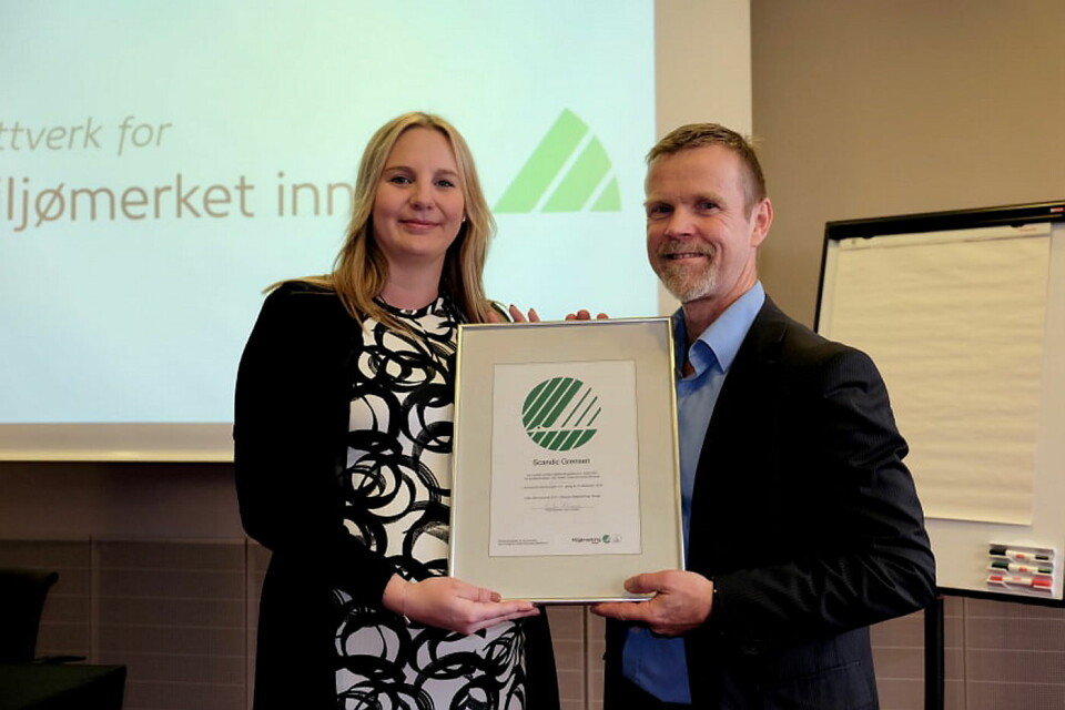 Therese Fredriksson, hotellsjef på Scandic Grensen, mottar bevis på at hotellet har blitt sertifisert med Nordens offisielle miljømerke fra Tormod Lien, Svanemerket. (Foto: Svanemerket)