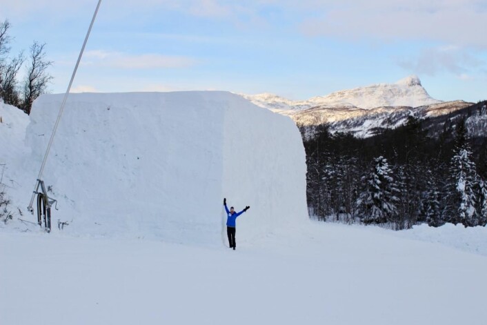 Snøkuben sett fra en annen vinkel, med Bitihorn i bakgrunnen. Prosjektleder Tone Greni står på bakken og gir oss en målestokk på dimensjonene. (Foto: DestinasjonsKirurgene) Snøkuben sett fra en annen vinkel, med Bitihorn i bakgrunnen. Prosjektleder Tone Greni står på bakken og gir oss en målestokk på dimensjonene. (Foto: DestinasjonsKirurgene)