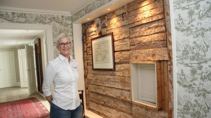 Den gamle tømmerveggen er bevart i Reymerts hus, viser hotelldirektør Therese Malmo. (Foto: Morten Holt) Den gamle tømmerveggen er bevart i Reymerts hus, viser hotelldirektør Therese Malmo. (Foto: Morten Holt)