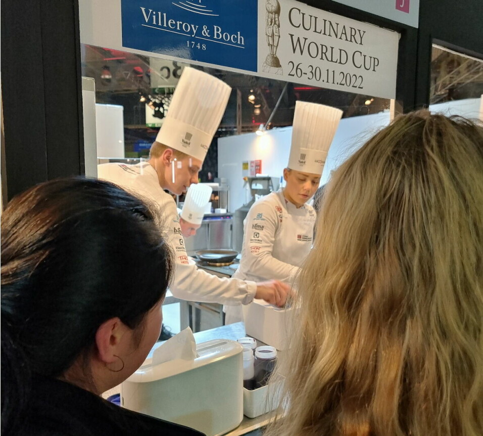 To av lærlingene følger med på hvordan det går inne i kokkeboksen da de norske kokkelandslagene konkurrerte i Culinary World Cup. (Foto: Asko Servering)