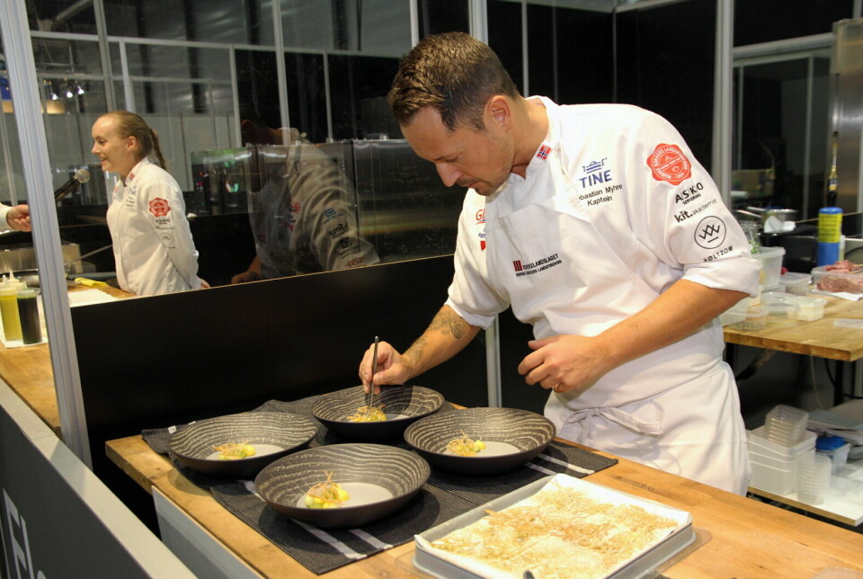 Kokkelandslagets kaptein Sebastian Myhre i aksjon i mesterkjøkkenet. I bakgrunnen Tonje Torvanger