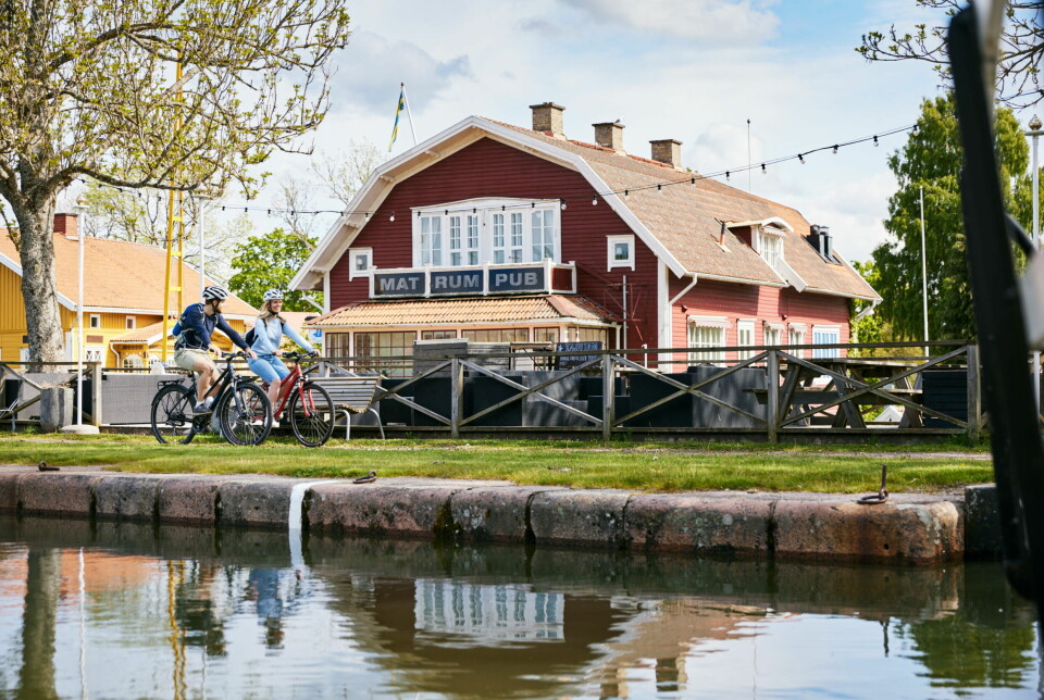 To på sykkel langs Göta kanal. Rødt hus med mat, rom og pub i bakgrunnen.