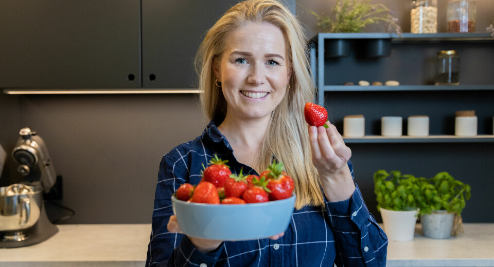 Iselin Bogstrand Sagen, på et kjøkken holder i et blått fat med jorbær.