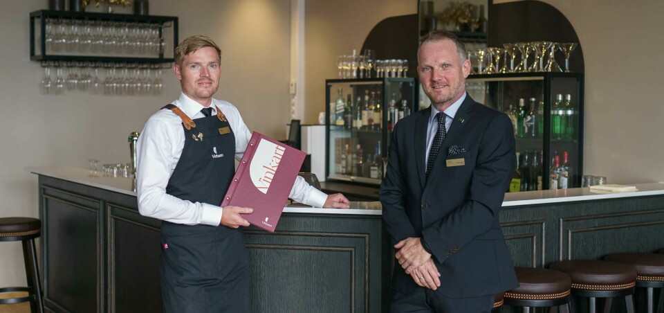 Restaurantsjef Even Eide (til høyre) og hotelldirektør Roy Heggdal (til venstre), stående ved bardisken med vinkartet.