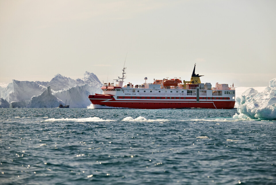 MS Sarfaq Ittuk ute på havet med isfjell i bakgrunnen.